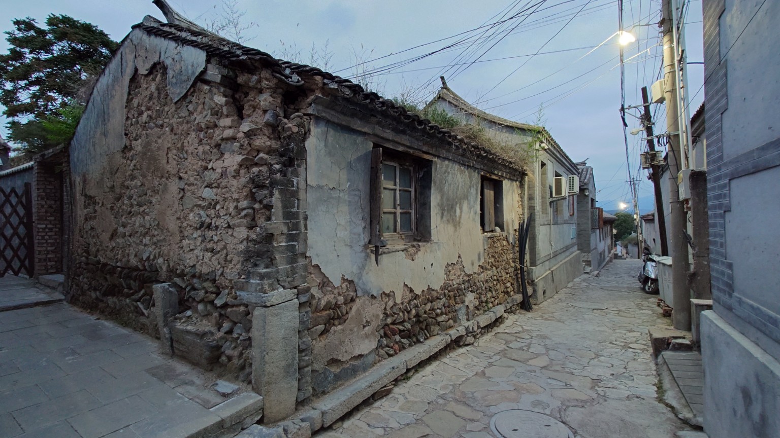 A stone lane beside a weathered traditional house in Lingshui Village