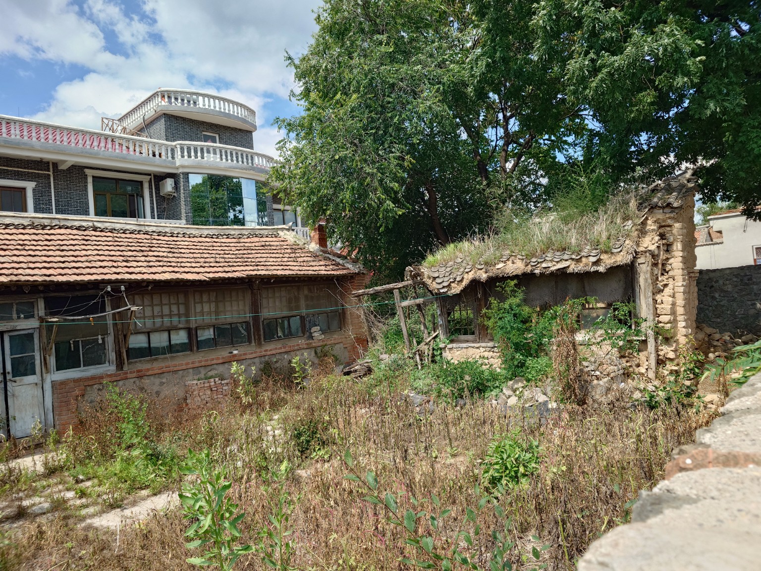 A contemporary house, an older tiled house and a partly collapsed structure in Liugou